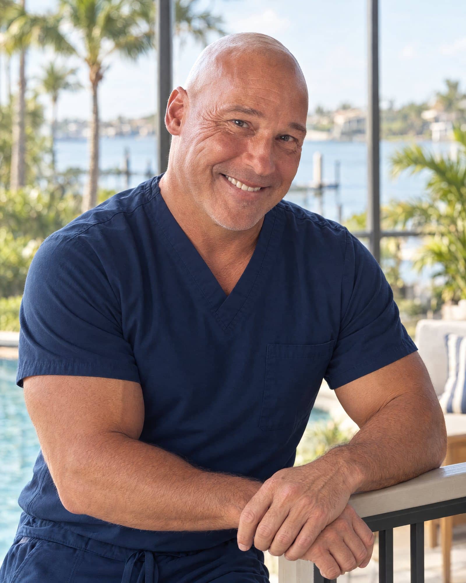 Dr. Robert Losier smiling on a Naples lanai overlooking the water
