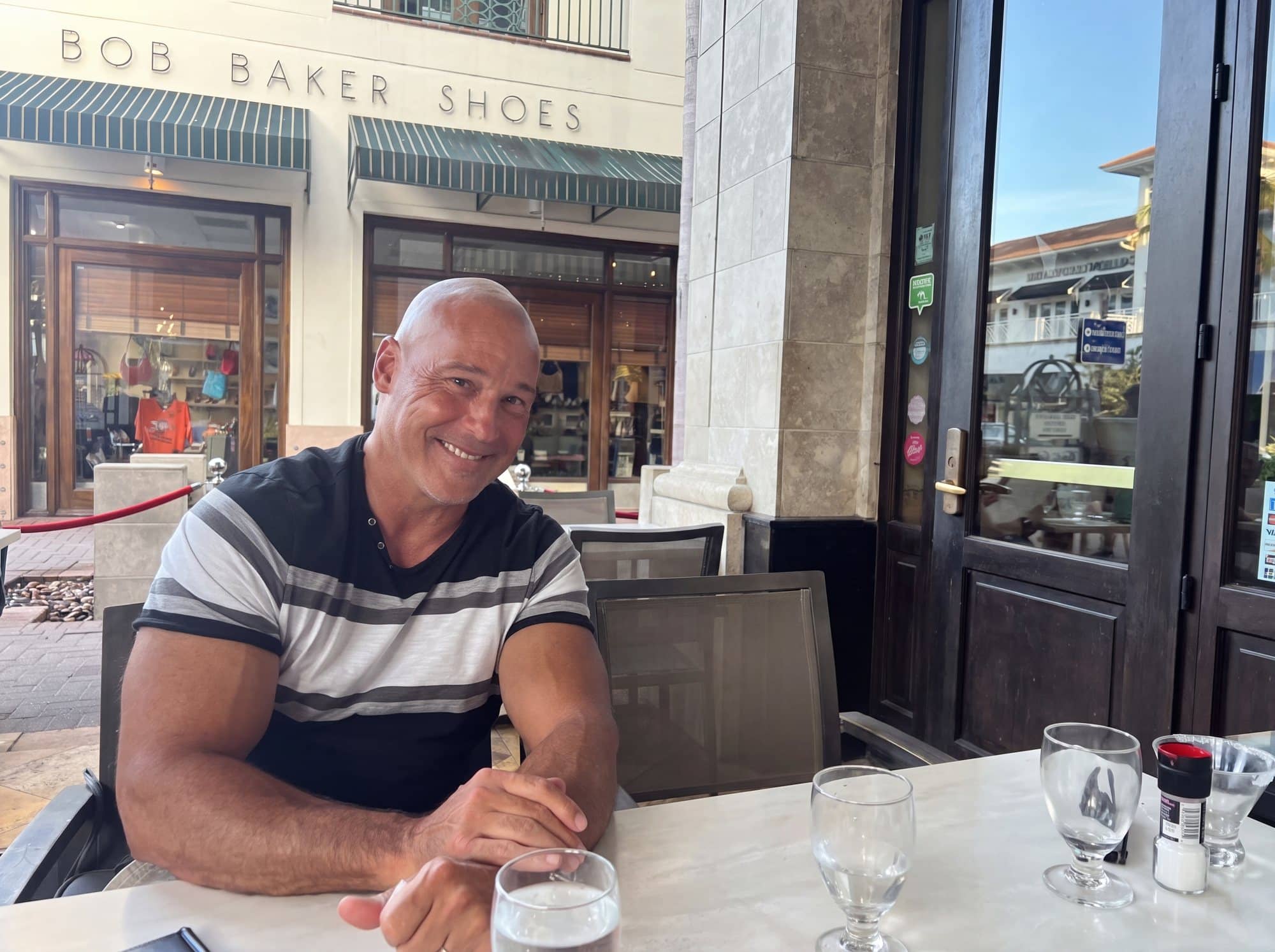 Dr. Robert Losier smiling at an outdoor café table in Naples